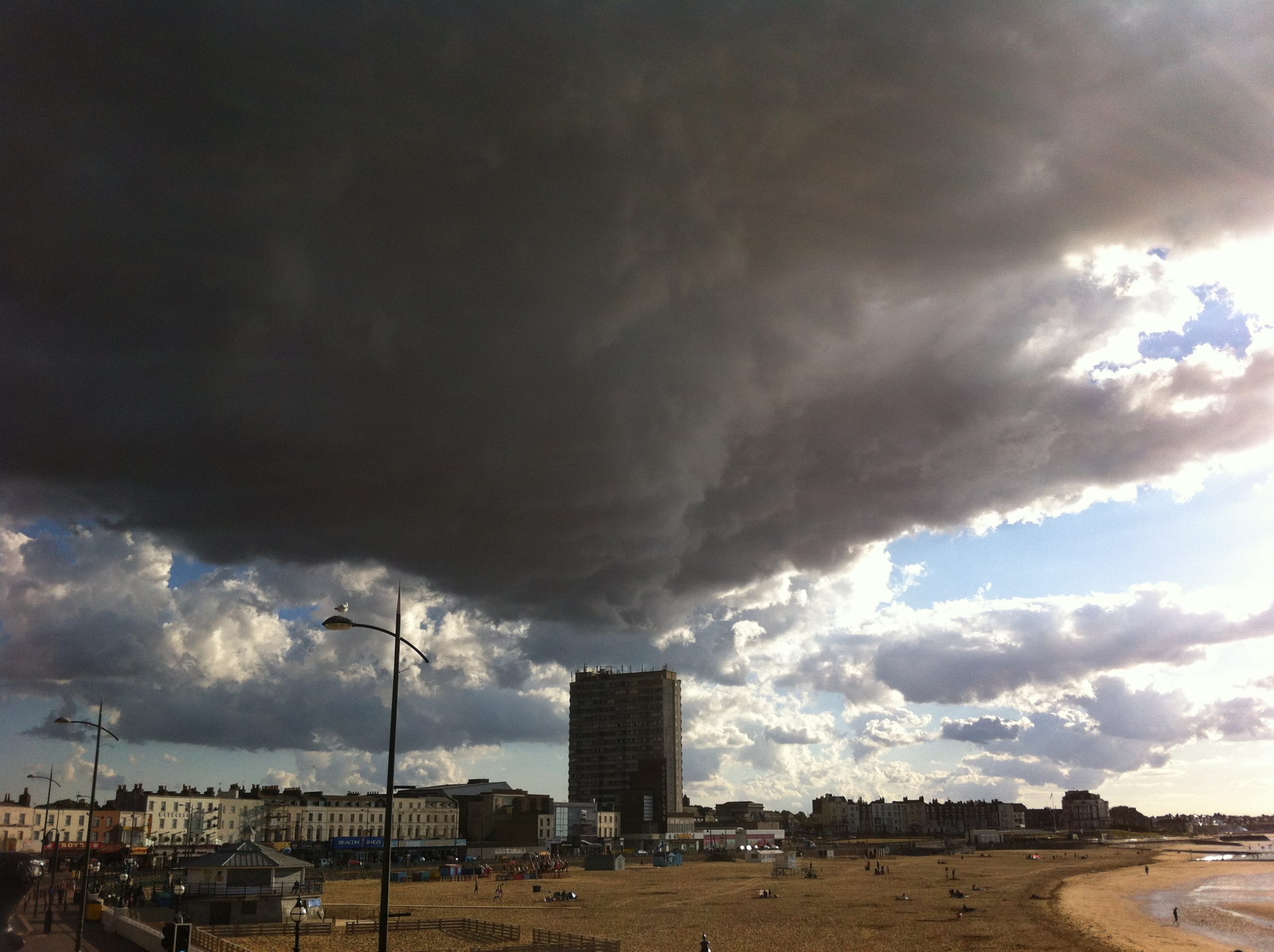 Photo of Margate beach with a dark black cloud looming overhead